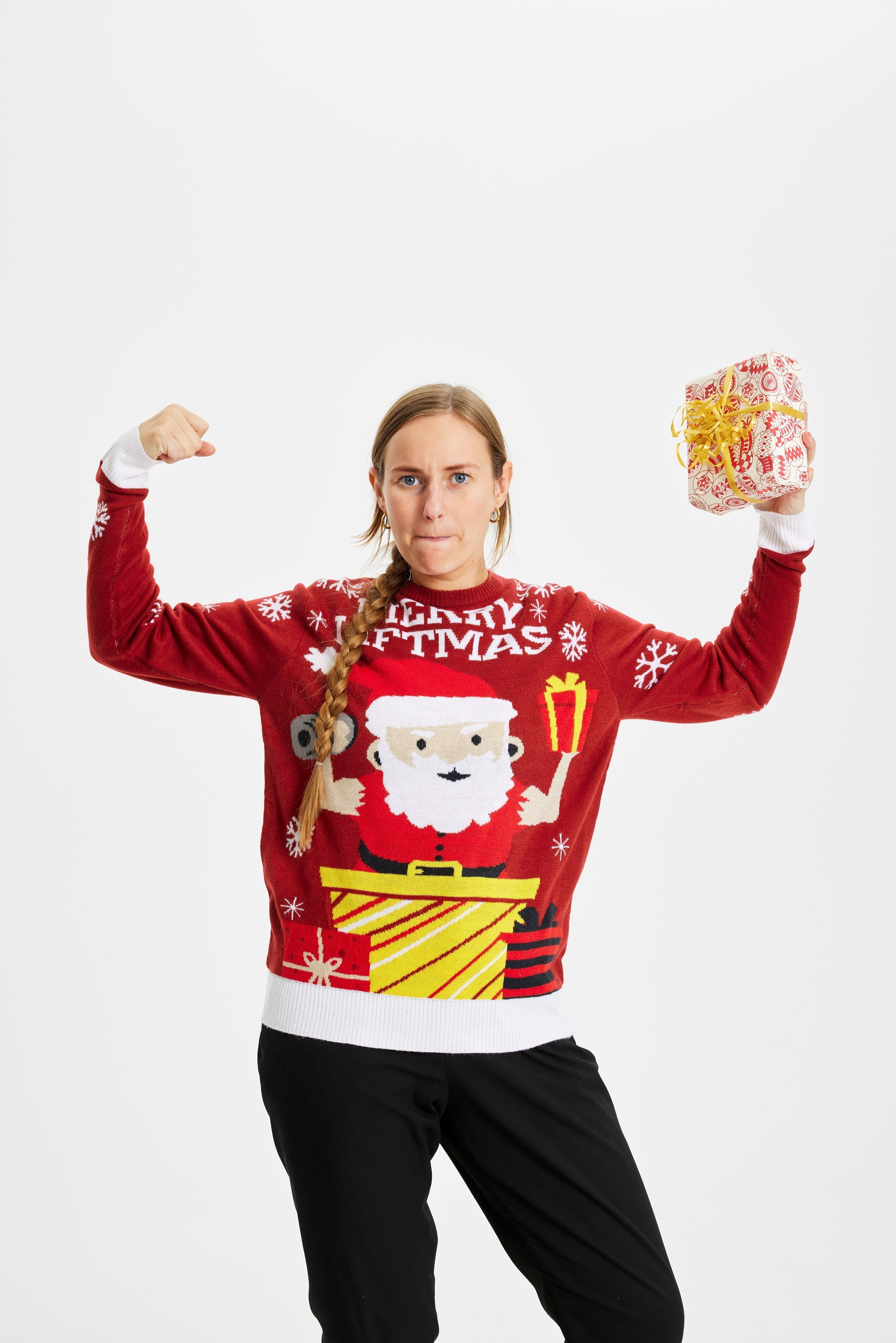 Une femme forte portant un pull de Noël rouge avec la citation